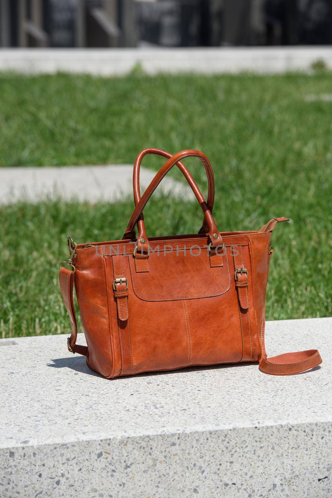 close-up photo of orange leather bag on a white marble by Ashtray25