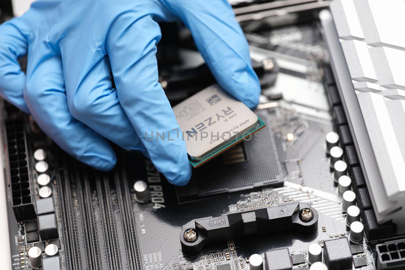 Tbilisi, Georgia - July 26, 2022: Installation of third generation Ryzen processor on motherboard. High performance microprocessor introduced by AMD concept