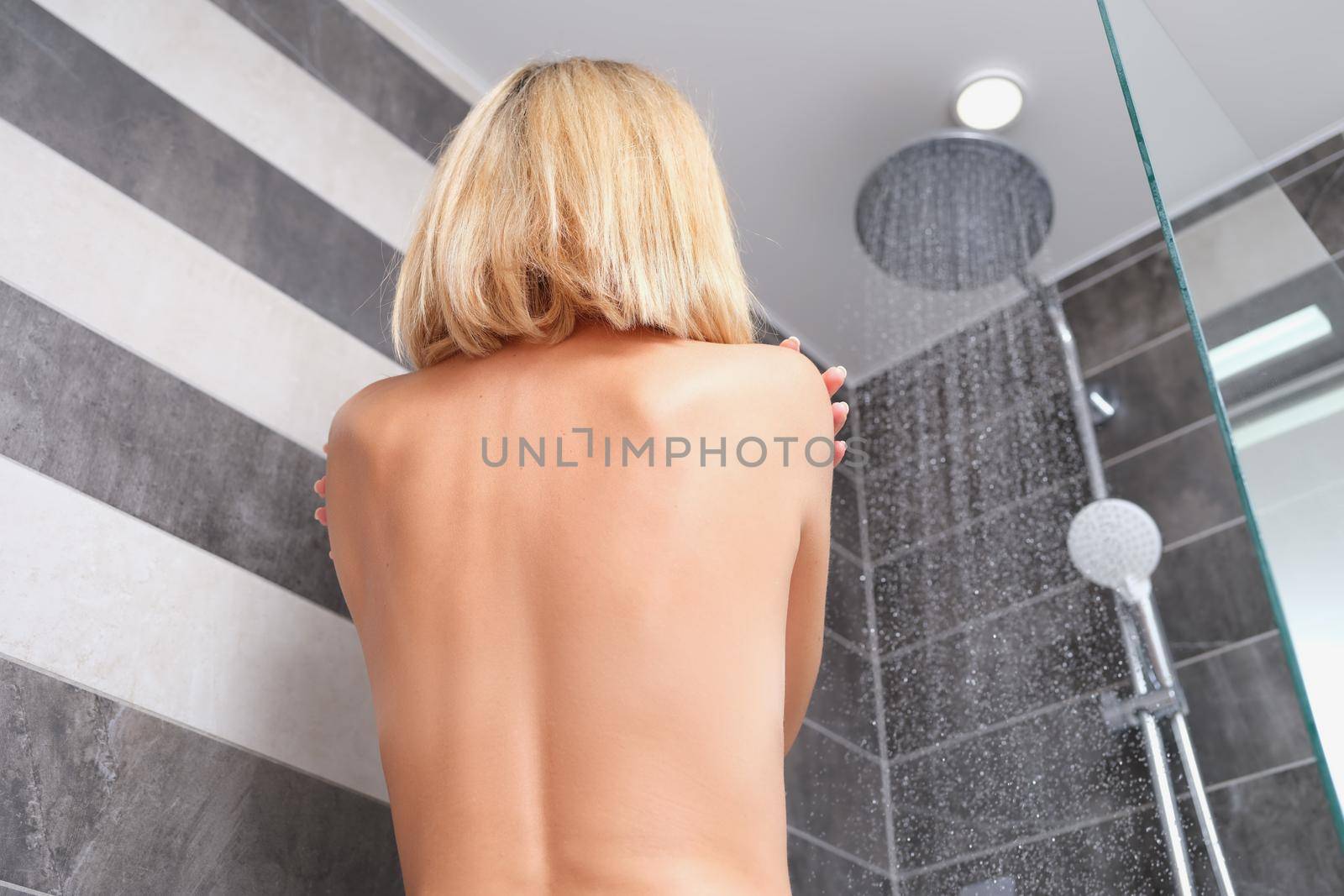 Naked woman bathes in shower and feels relaxed and clean by kuprevich