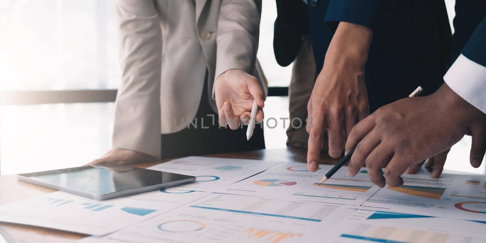 Team business people hand pointing at business document during discussion at meeting. by wichayada