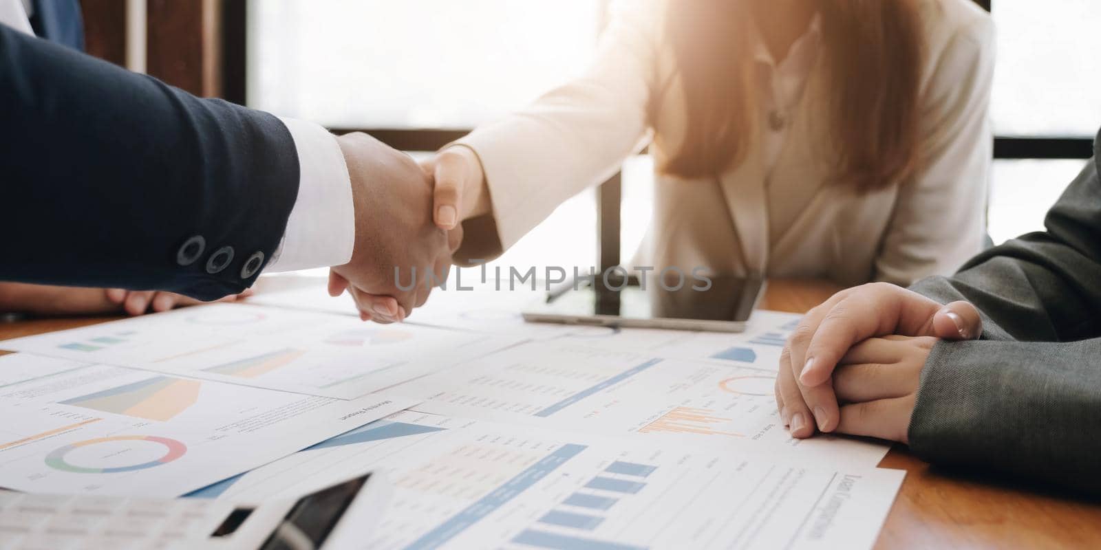 Two confident business man shaking hands during a meeting in the office, success, dealing, greeting and partner concept. by wichayada