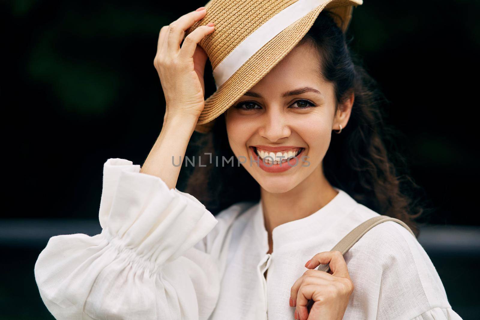 Portrait of a smiling girl with curly-haired brunette girl in a hat. High quality photo