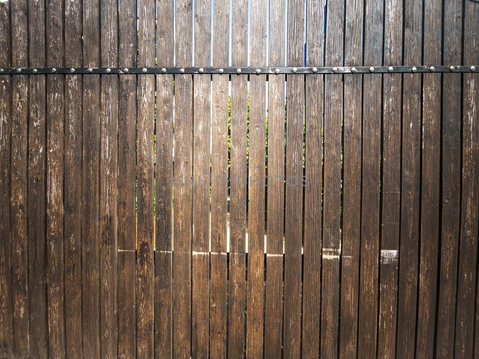 Fence made of vertical boards of natural wood in full screen