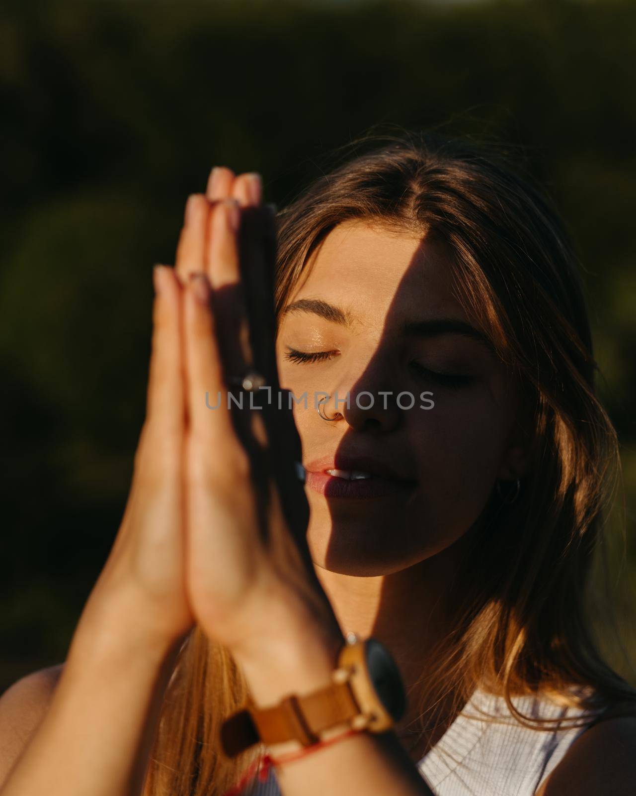 Close Up Portrait Young Woman Practicing Yoga and Meditation with Folded Hands Outdoors at Sunset by Romvy