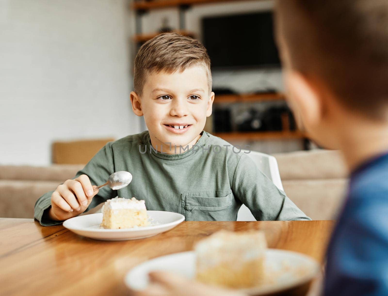 Portrait of two brothers eating cake at home