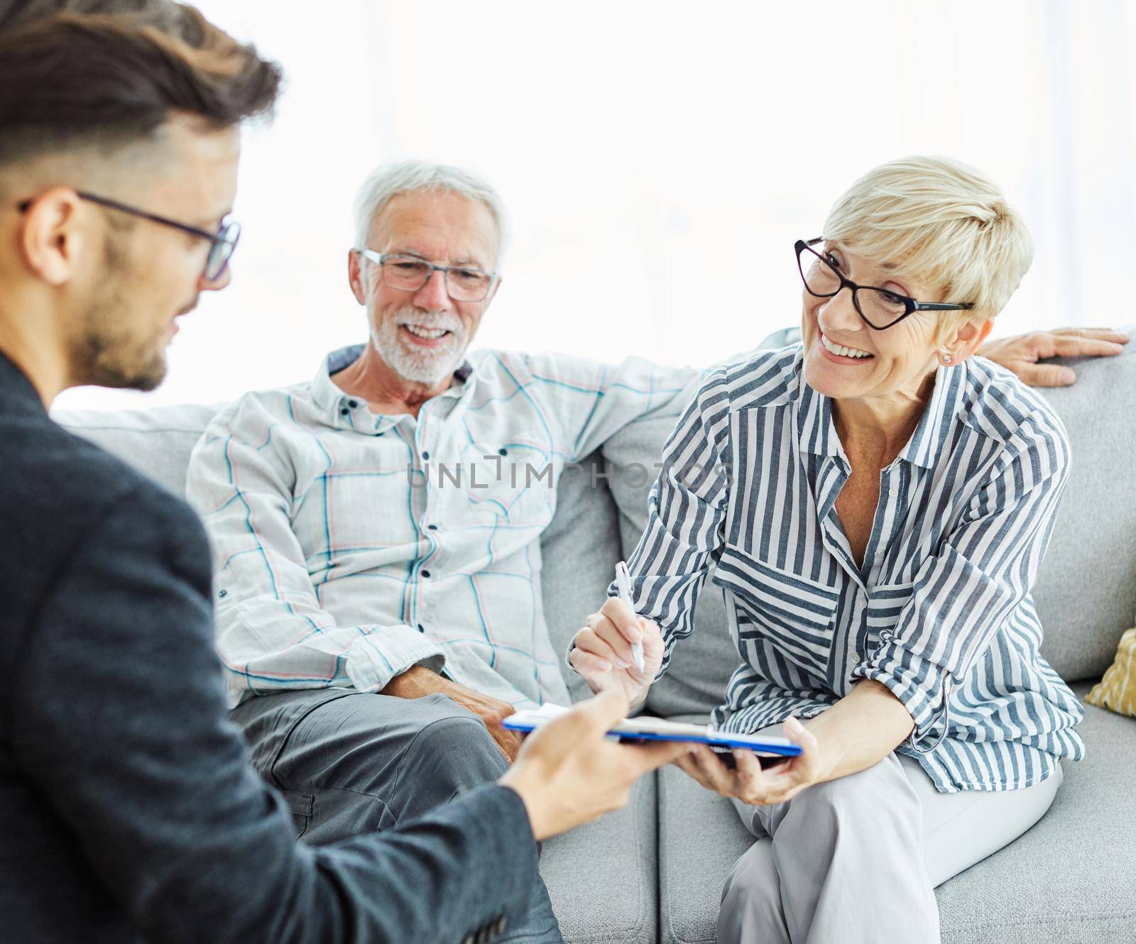 Happy senior old family couple clients make financial insurance estate business deal contract signing, agent lawyer, satisfied mature customers sogning contract meeting bank manager agree on investment contract