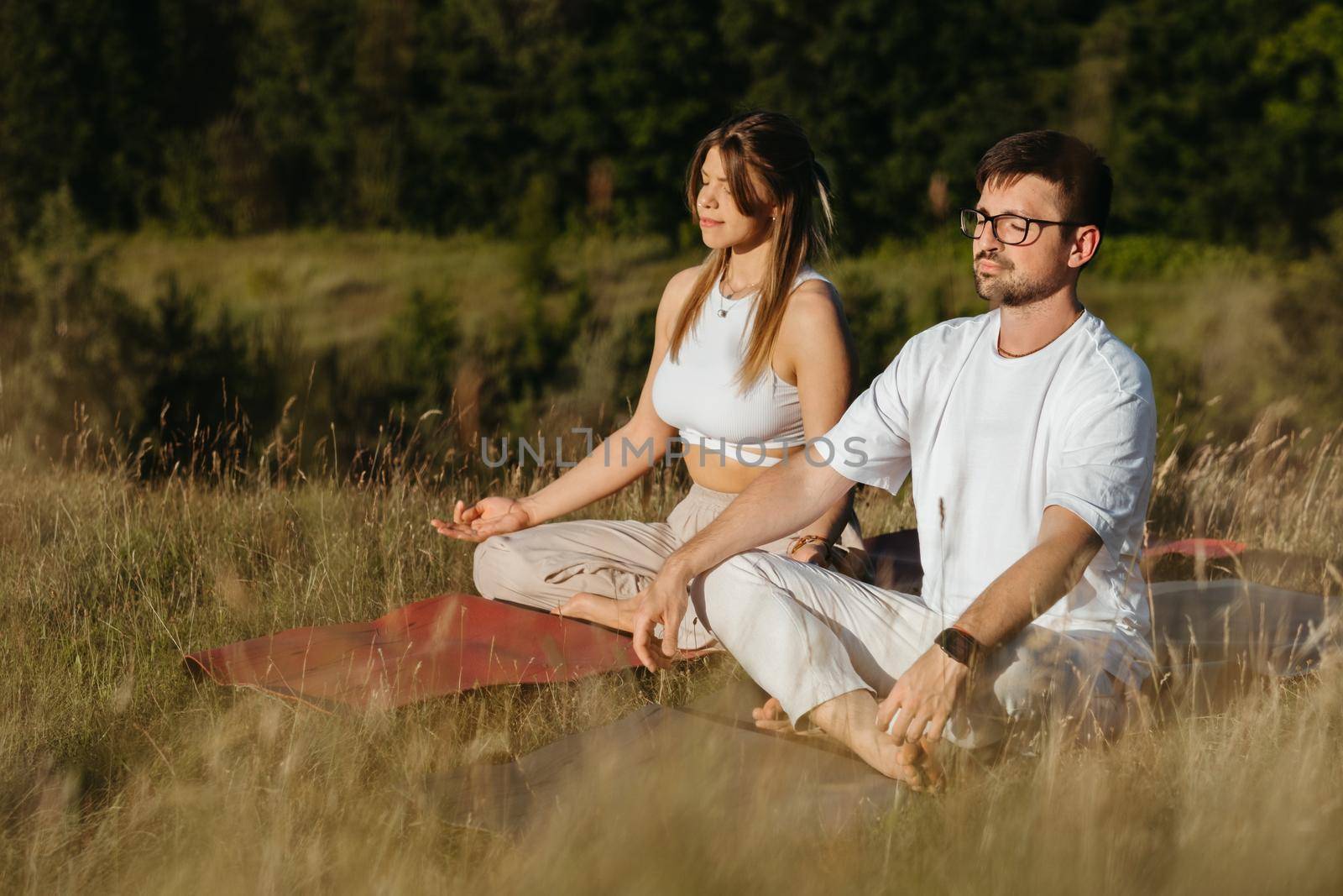 Caucasian Woman and Man Dressed Alike Breathing Fresh Air in the Nature, Young Adult Couple Meditating Outdoors by Romvy