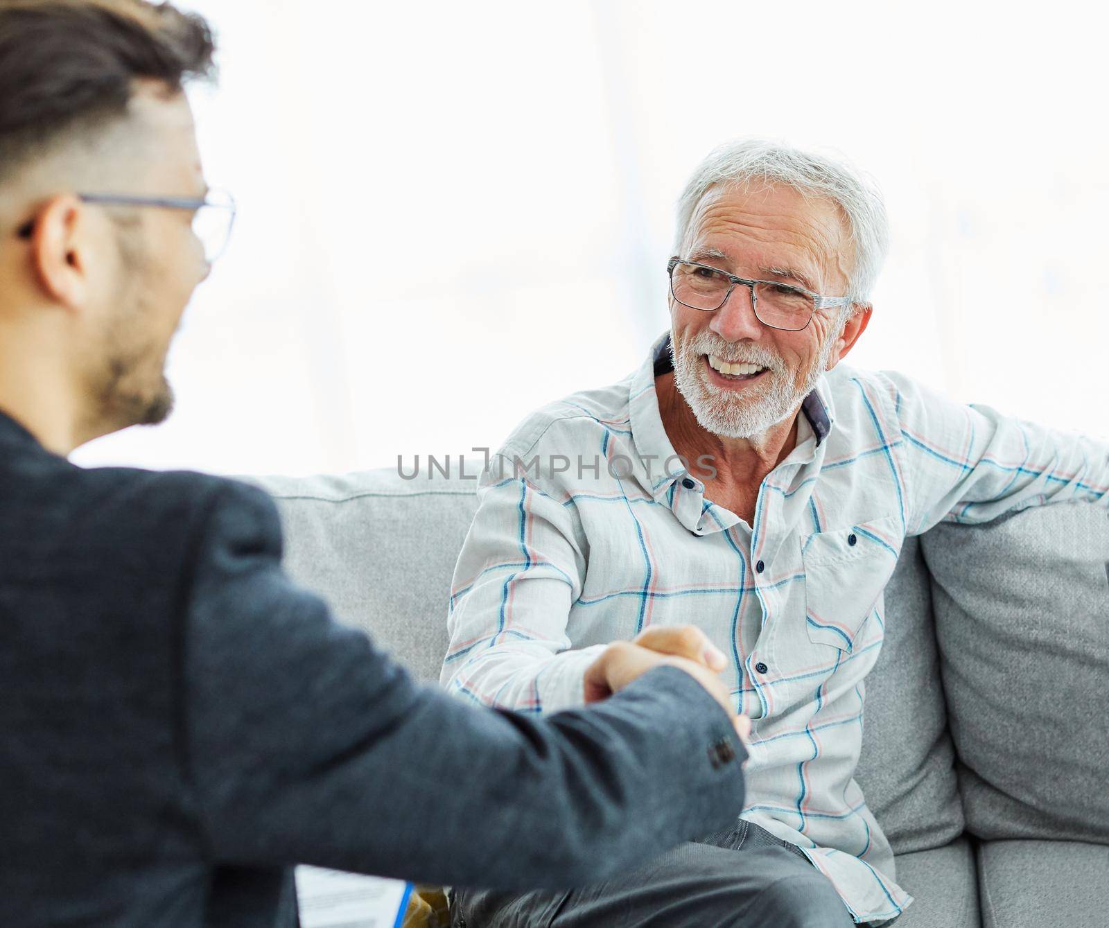 Happy senior old family couple clients make financial insurance estate business deal handshake agent lawyer, satisfied mature customers shake hand meeting bank manager agree on investment contract, contract signing