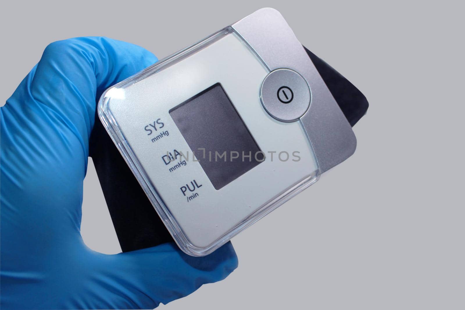 The doctor's hand in a blue medical glove holds a tonometer. Medicine concept.