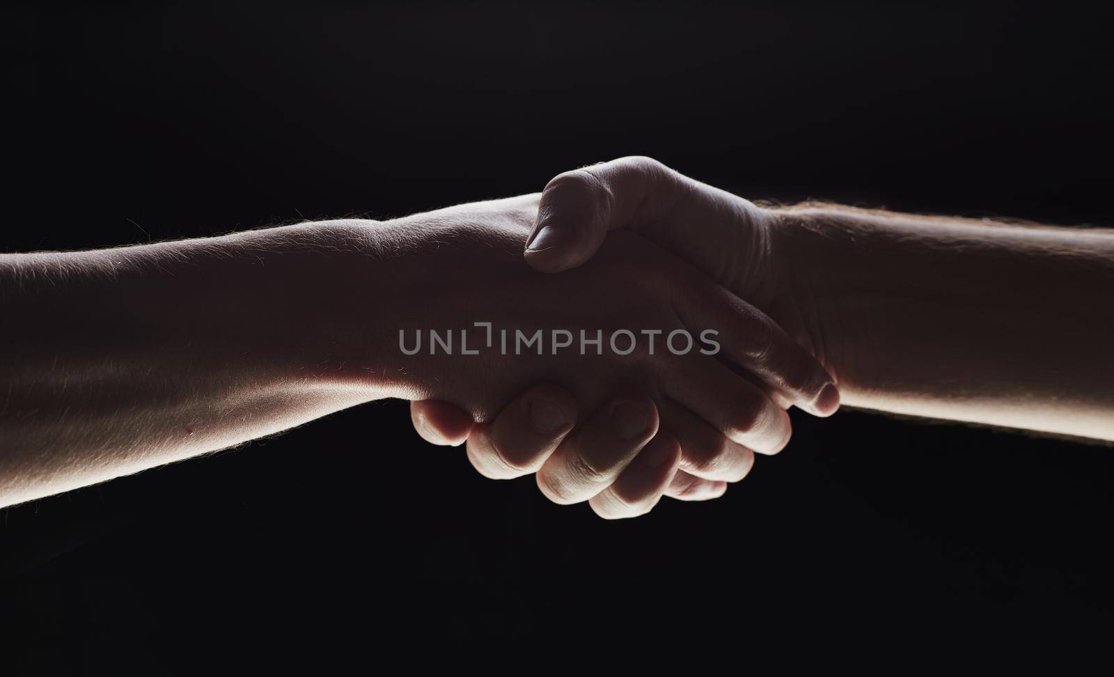 Photo of two men shaking hands on a black background by Prosto