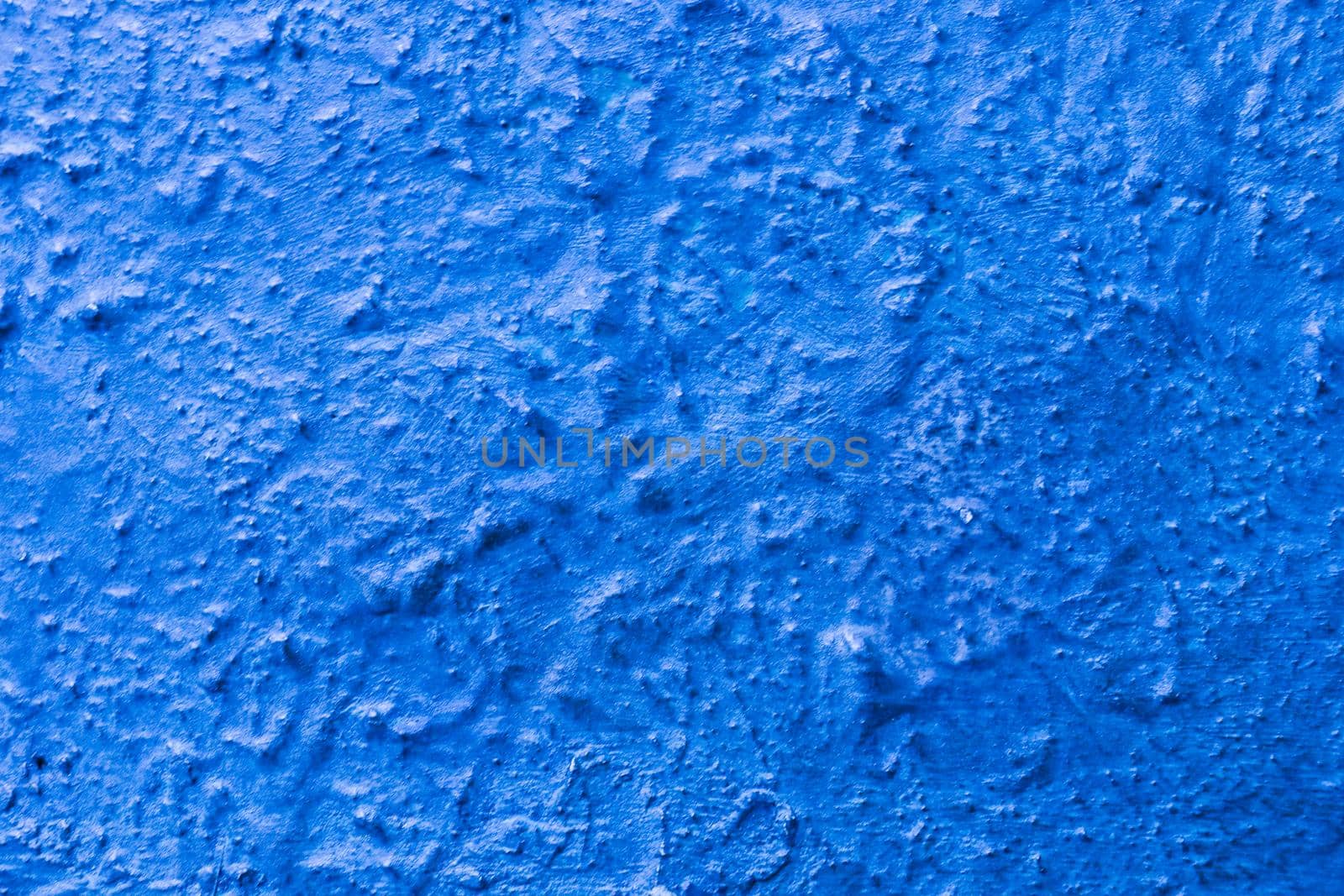 Abstract background from the relief surface of bronze painted with blue paint. blue wall old.