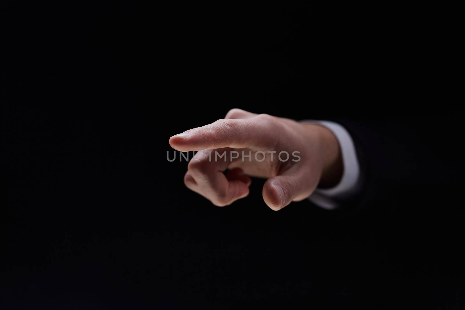 Hand isolated on black background with index finger extended by Prosto