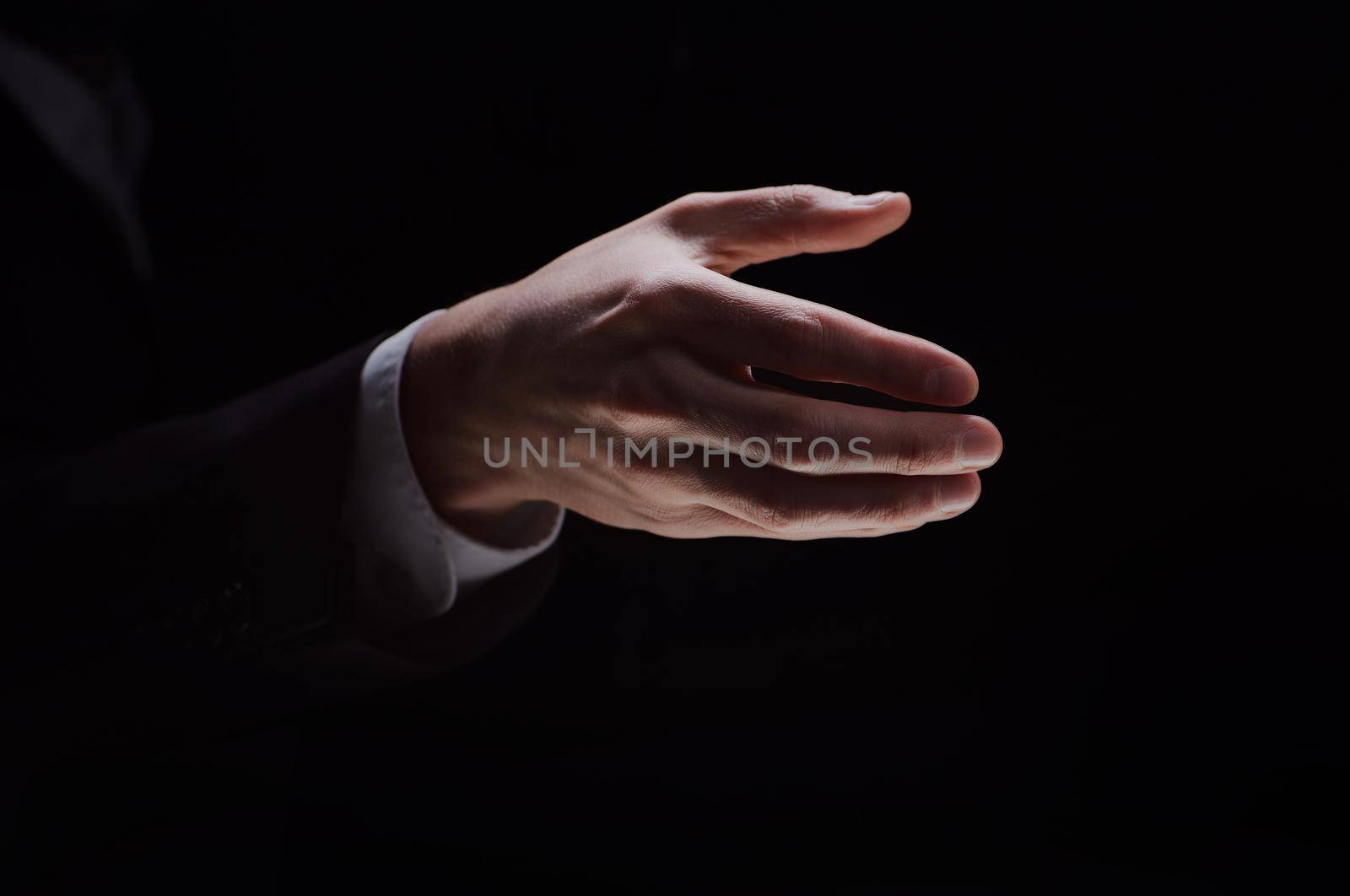A man holds out his hand for a handshake, highlighted on a black background by Prosto