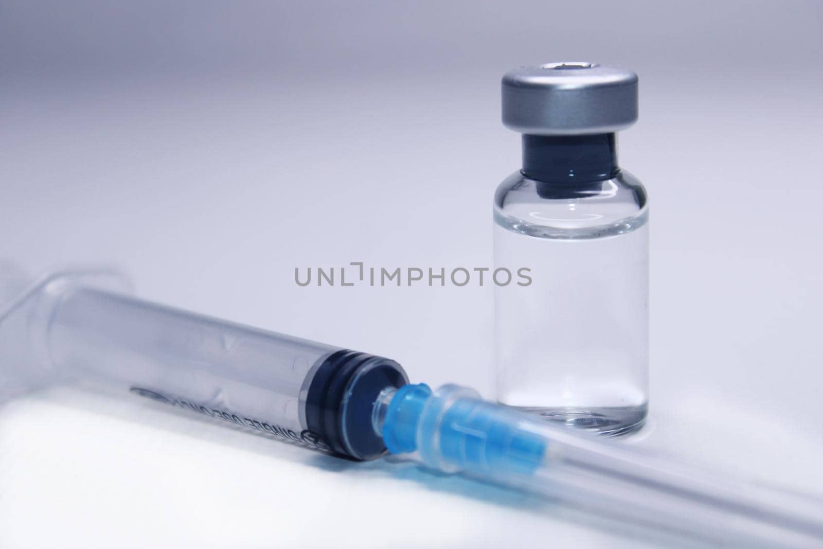 Syringe and a bottle of medicine close-up on a light background. Blurred background.