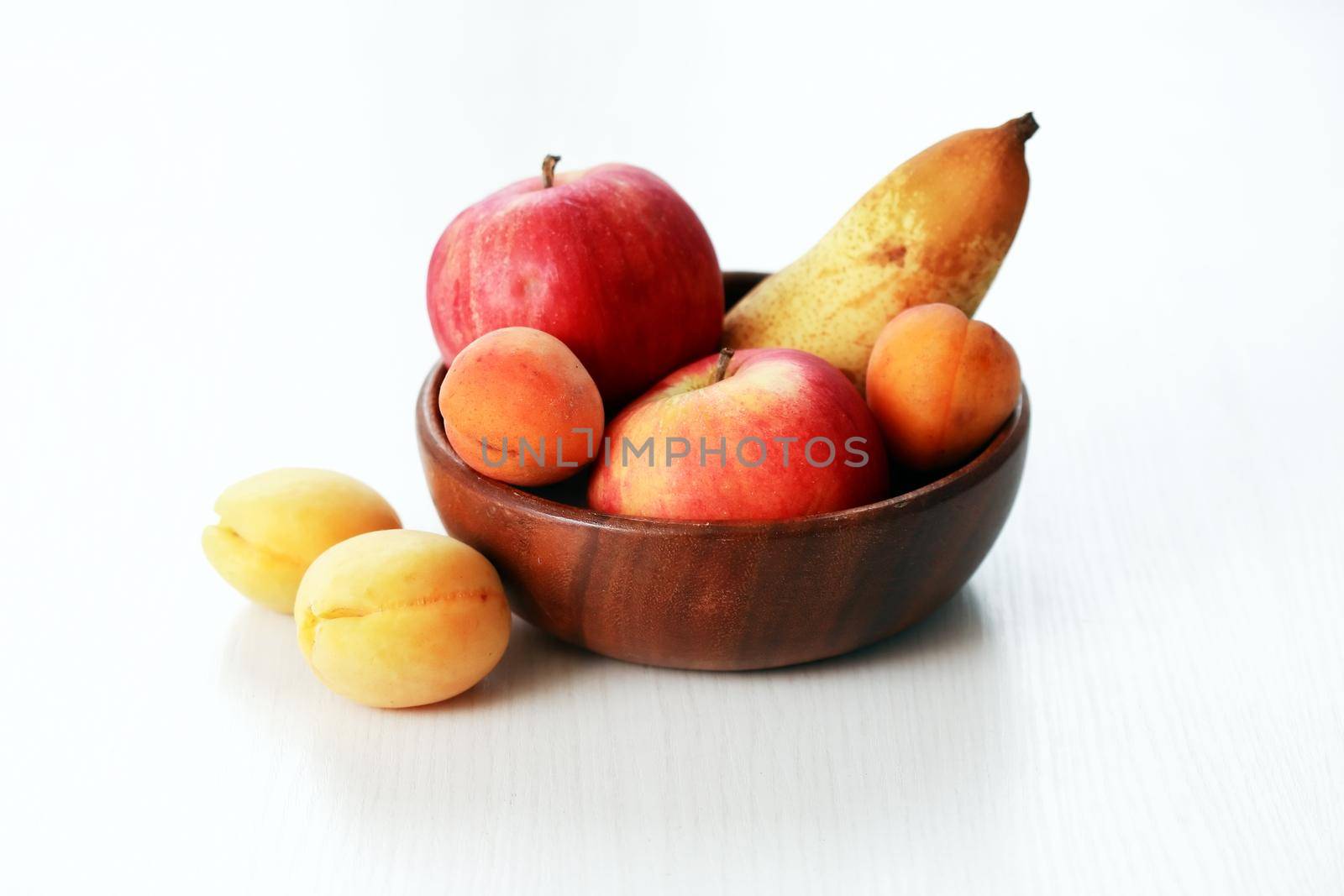 Heap of freshness fruits in wooden bowl on white background