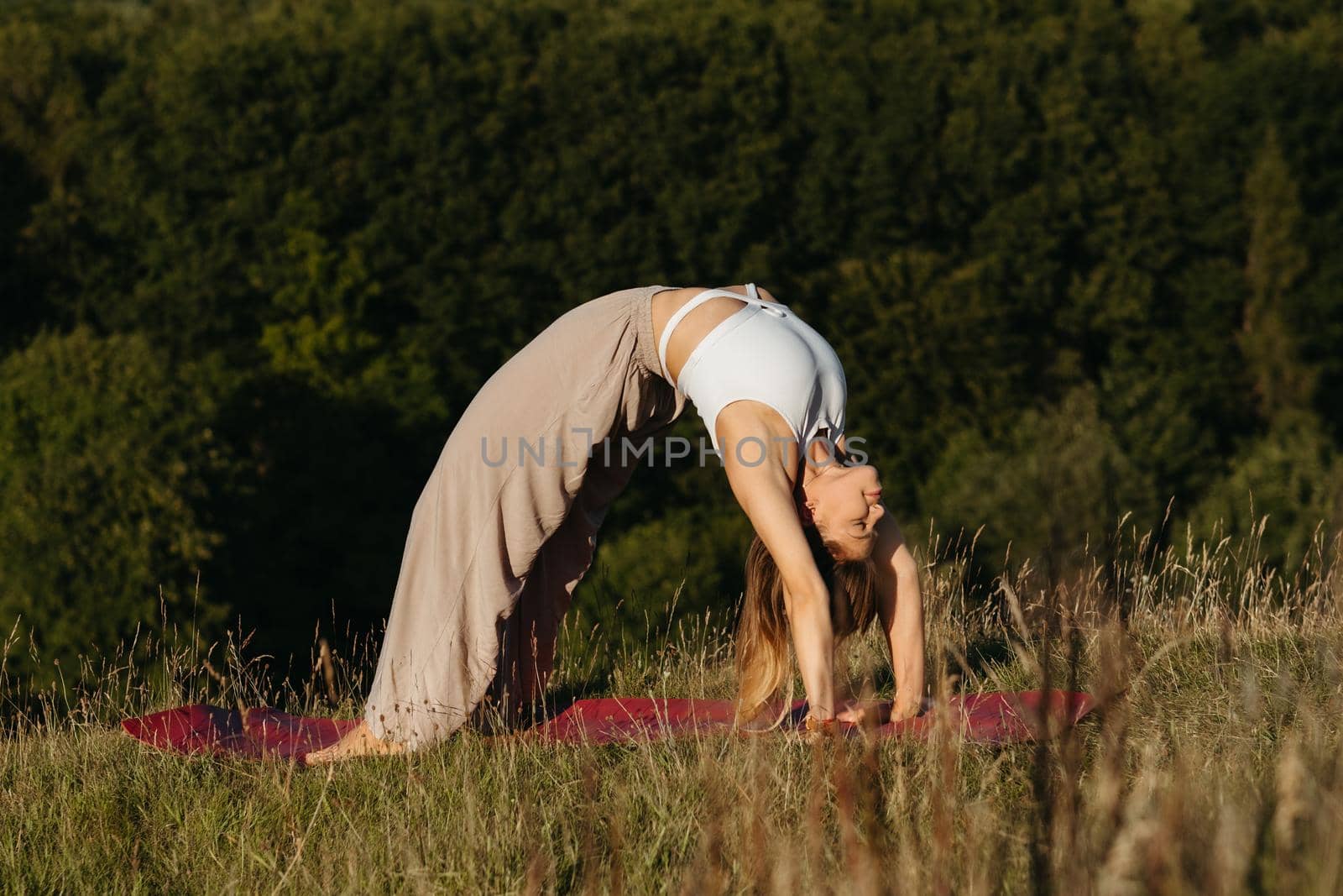 Young Woman Doing Bridge Exercise During Yoga Outdoors with Beautiful Background
