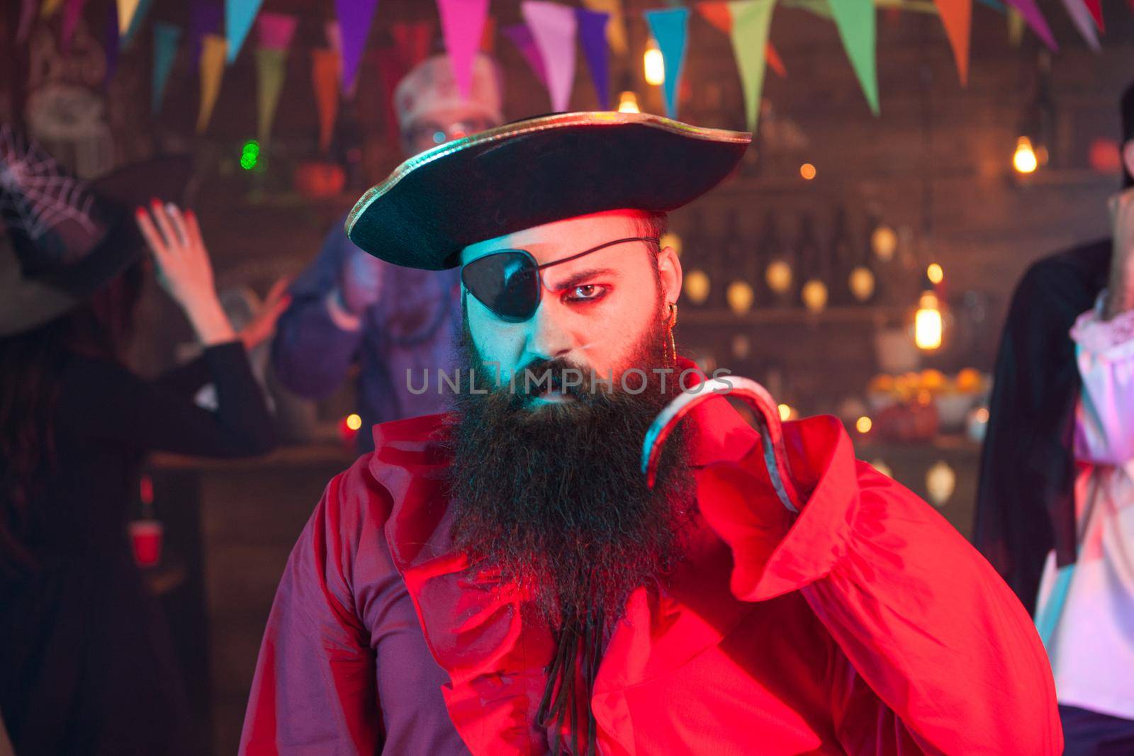 Portrait of man dressed up like pirate looking angry at the camera while celebrating halloween. Halloween costume.