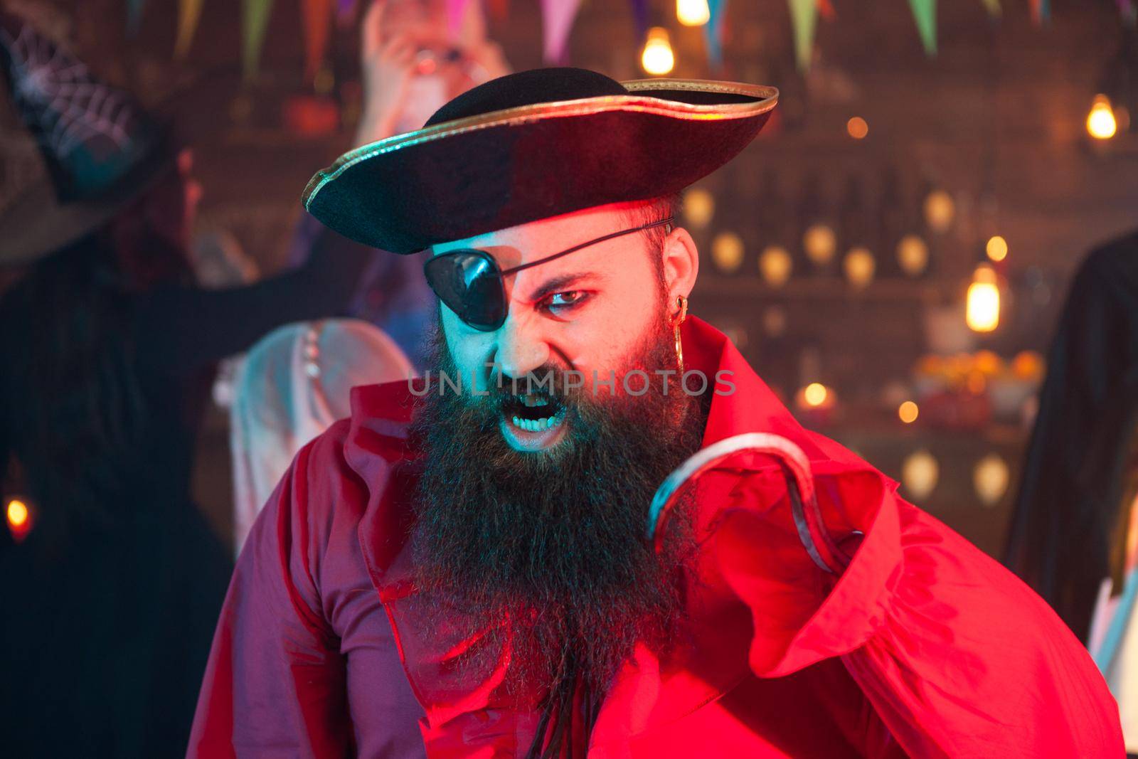 Portrait of handsome bearded man screaming and dressed up like a pirate at halloween celebration by DCStudio