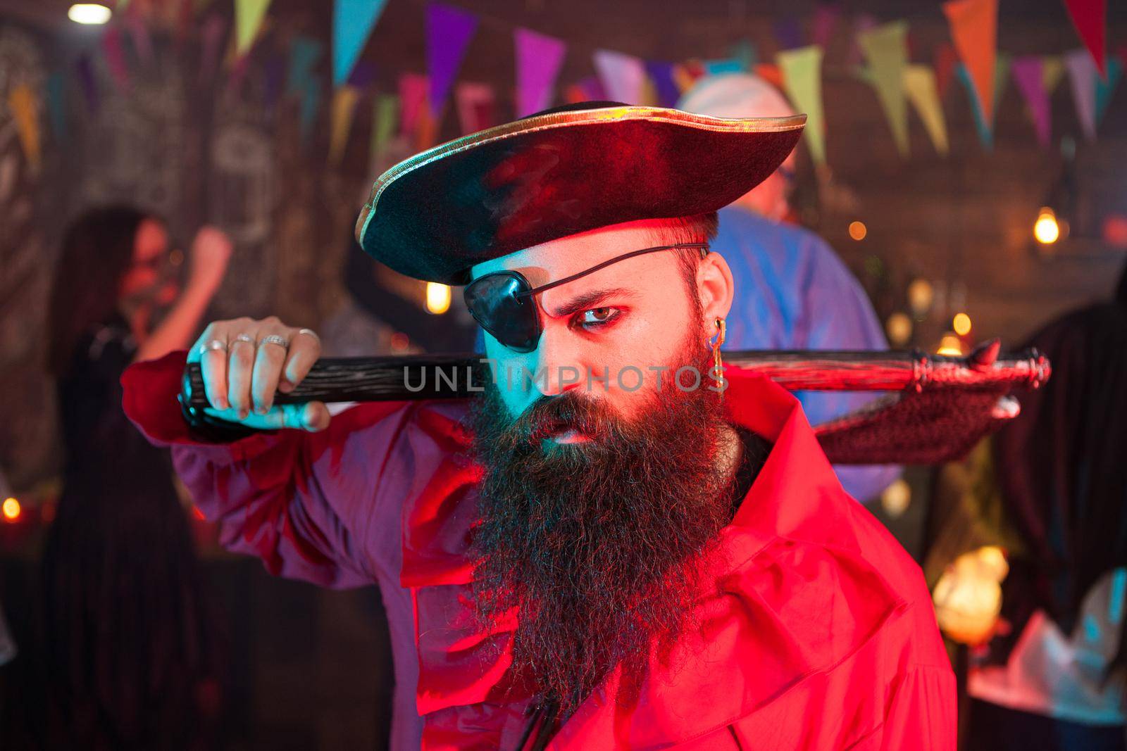 Angry pirate celebrating halloween with his friends. Man dressed up like a pirate with a big hat.