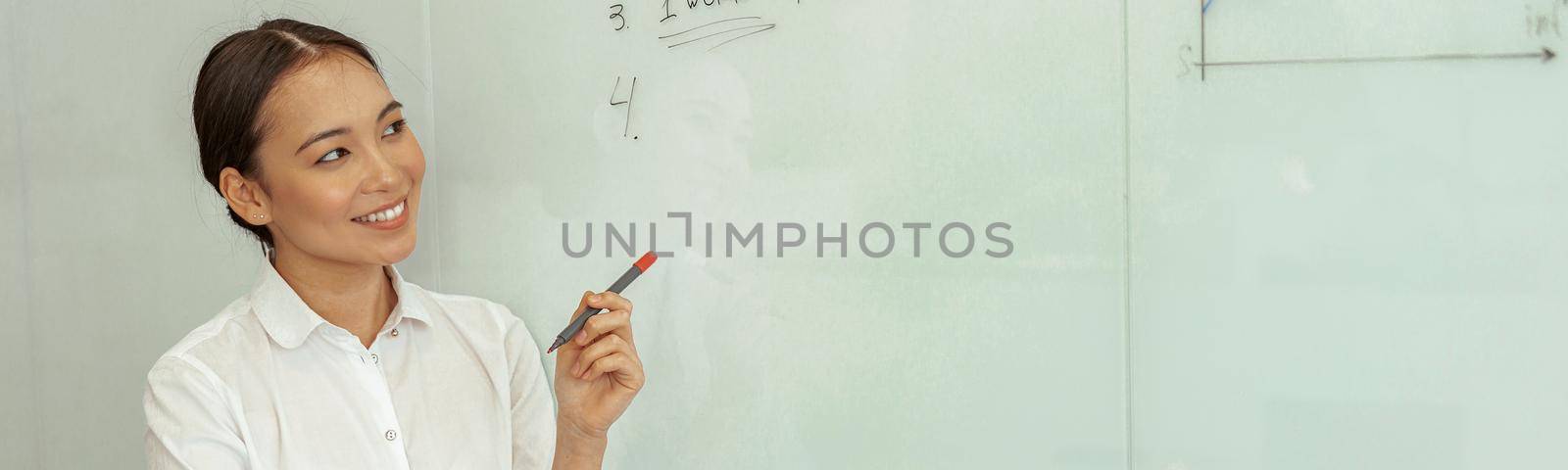 Asian business woman looking on flipboard with charts stand in meeting room by Yaroslav_astakhov