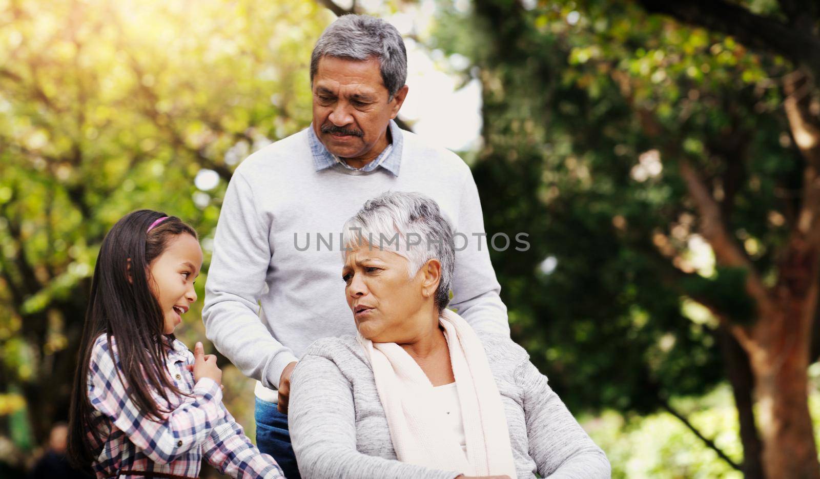 She always has interesting stories to tell us. an adorable little girl spending some time with her grandparents at the park. by YuriArcurs