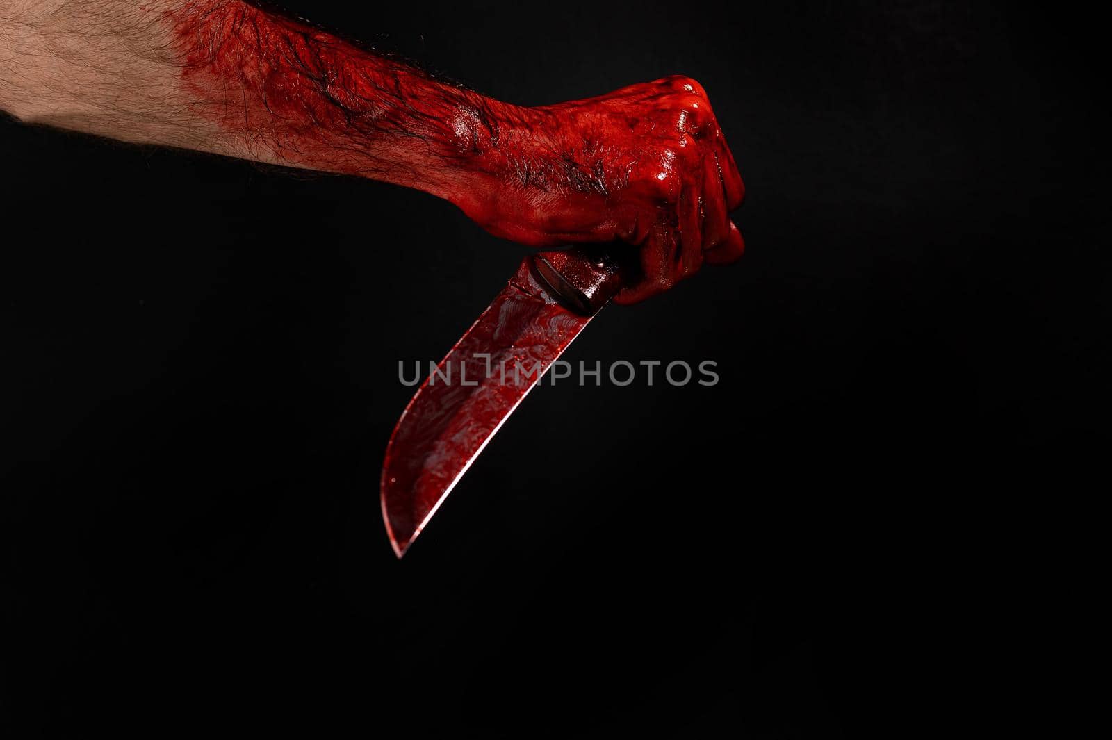 Man holding knife with bloody hand on black background. by mrwed54