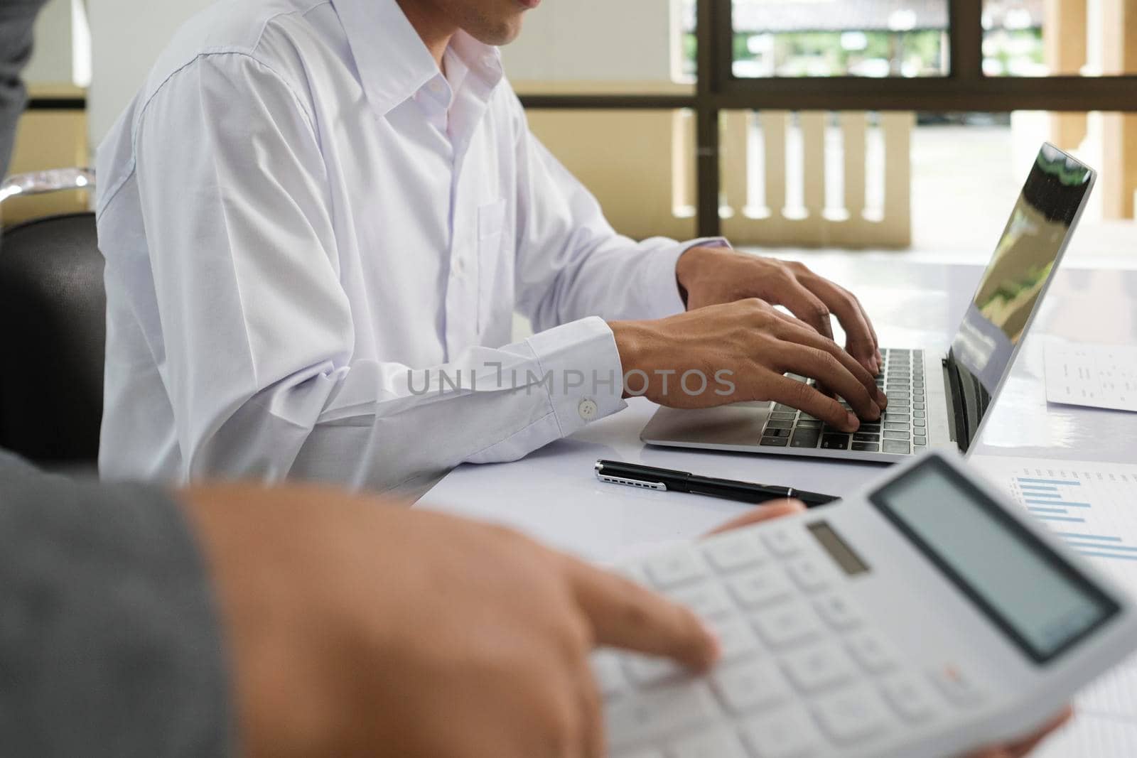 Close up asisan businessman teamwork meeting and discussing the investment data and report graph Businessman teamwork on laptop and calculator Teamwork meeting working concept.