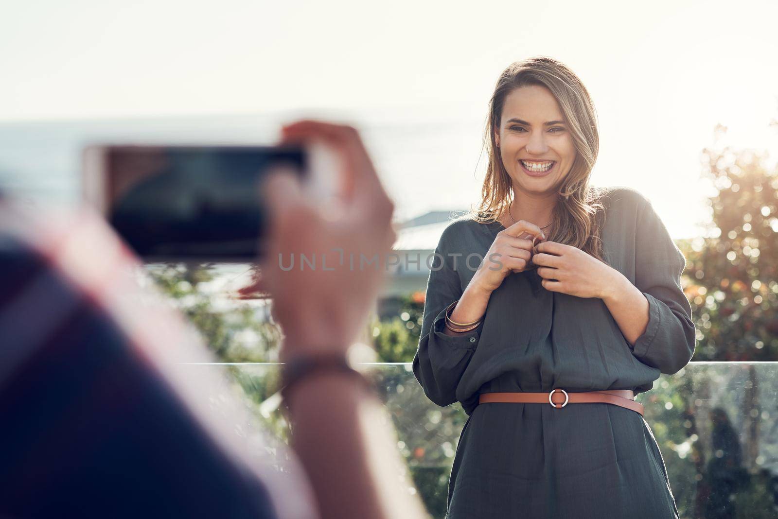 My own beauty queen. an attractive young woman laughing while her boyfriend takes pictures of her outdoor