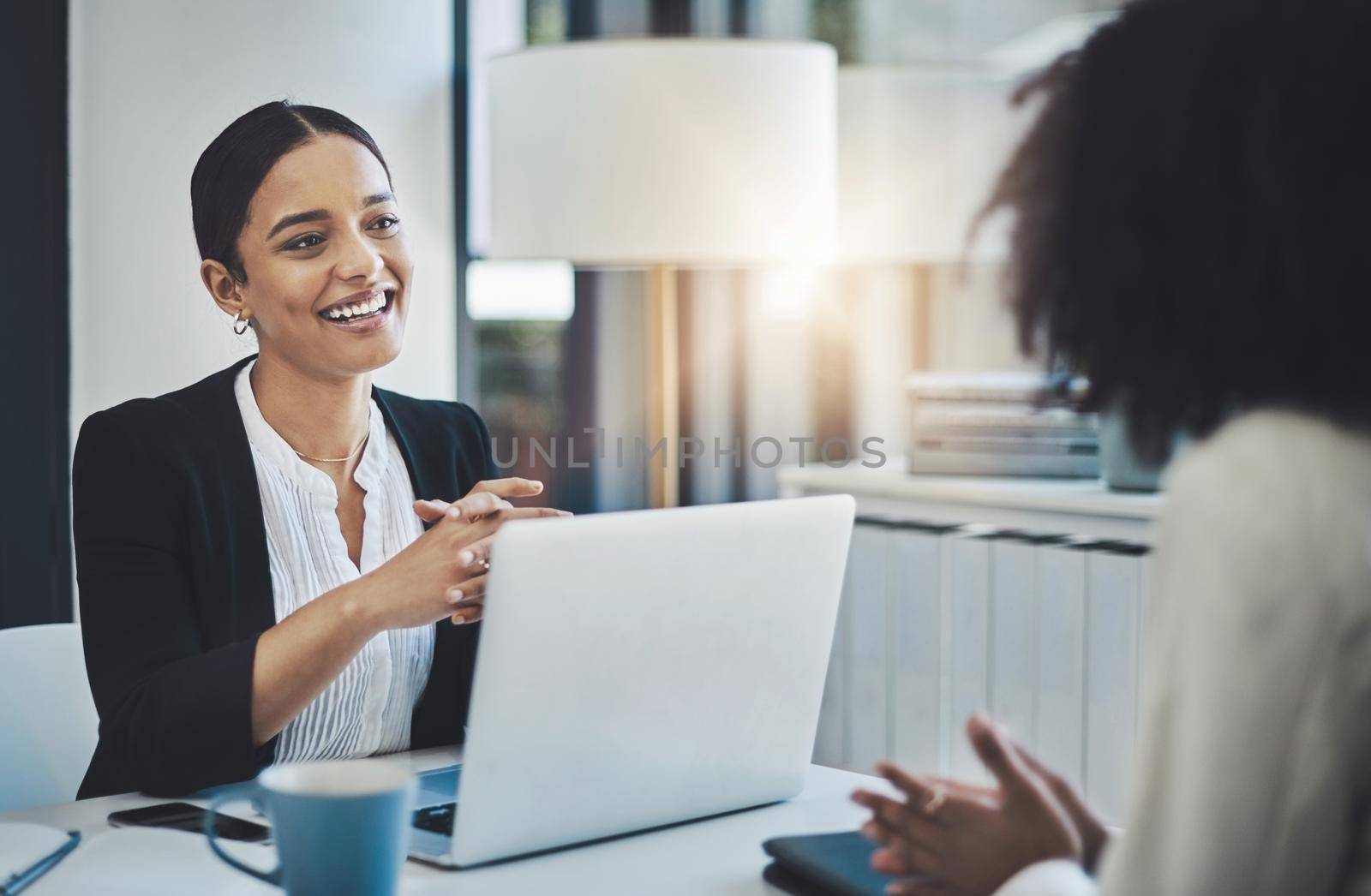 Discussing new ways to achieve success in business. two businesswomen having a discussion in an office. by YuriArcurs