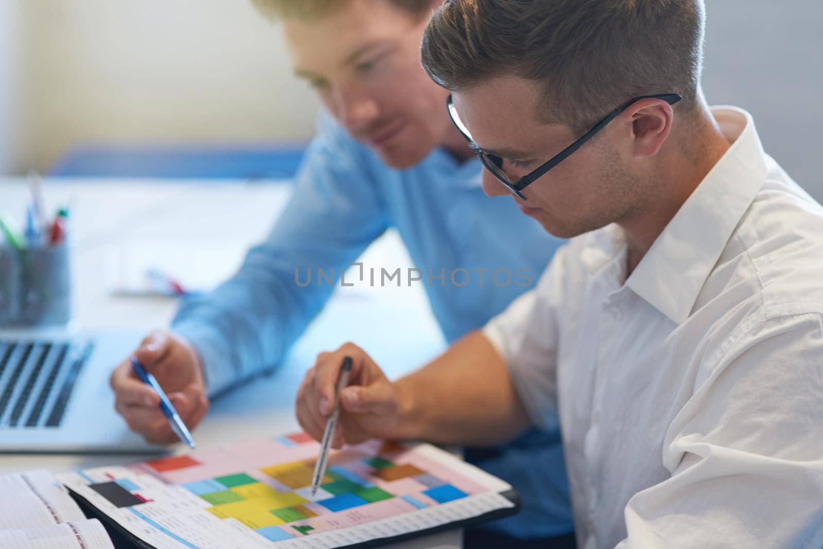 Planning our schedule for this busy month. two handsome young businessmen working together in their office