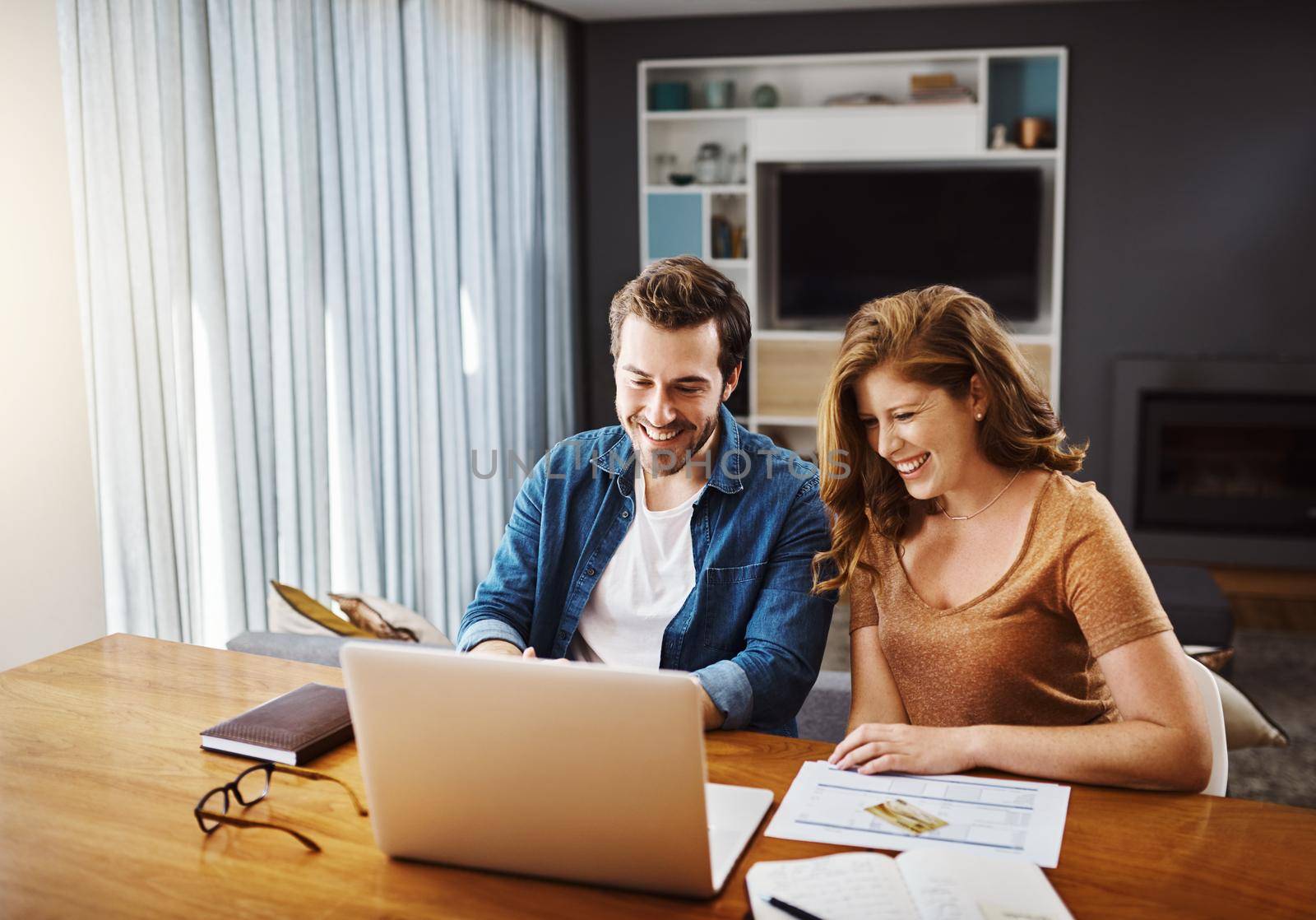 Teaming up to make the best financial choices. a young couple watching online videos together while doing their monthly budget at home