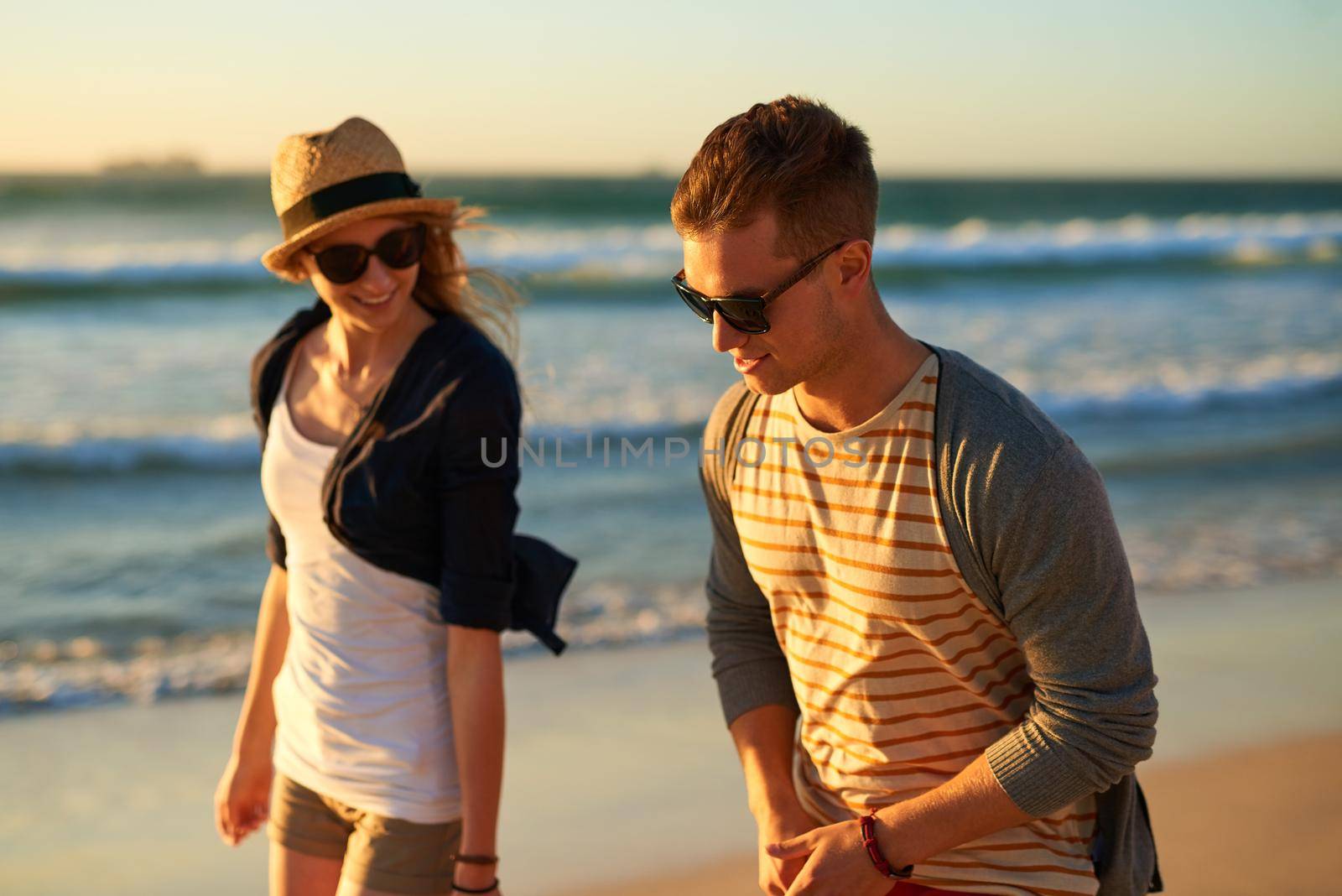 Loving you and loving the beach. n affectionate young couple taking a walk together on the beach