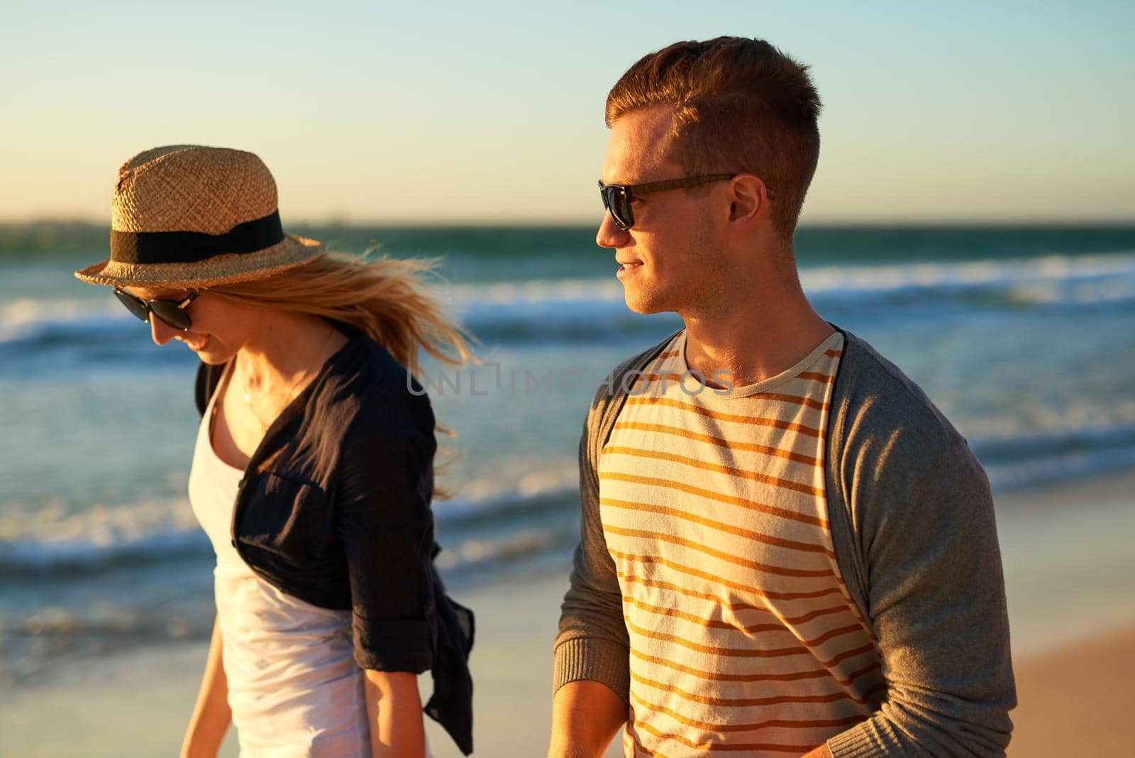 Summer, the season to fall in love. n affectionate young couple taking a walk together on the beach