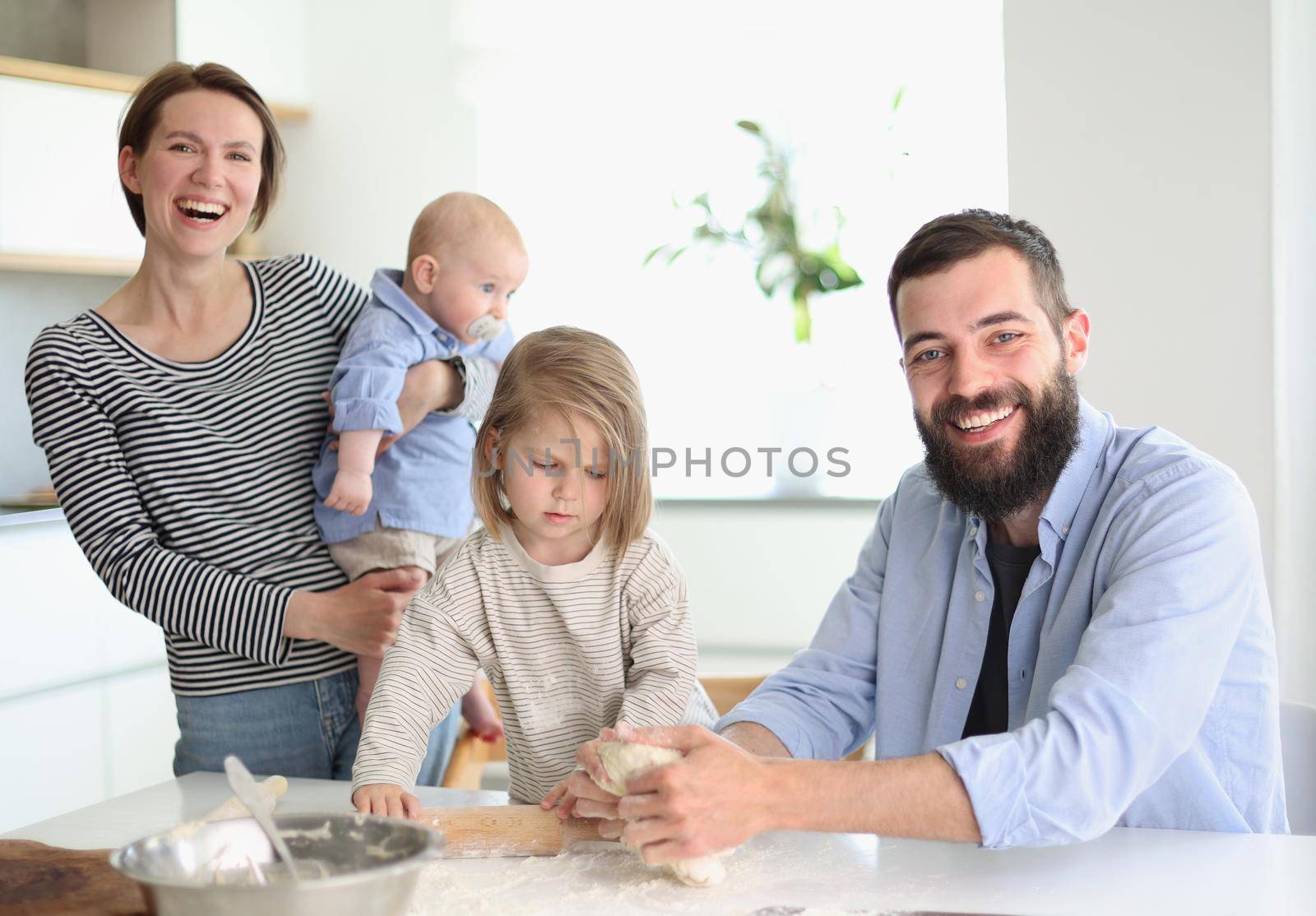 Young family with daughter and son in the kitchen