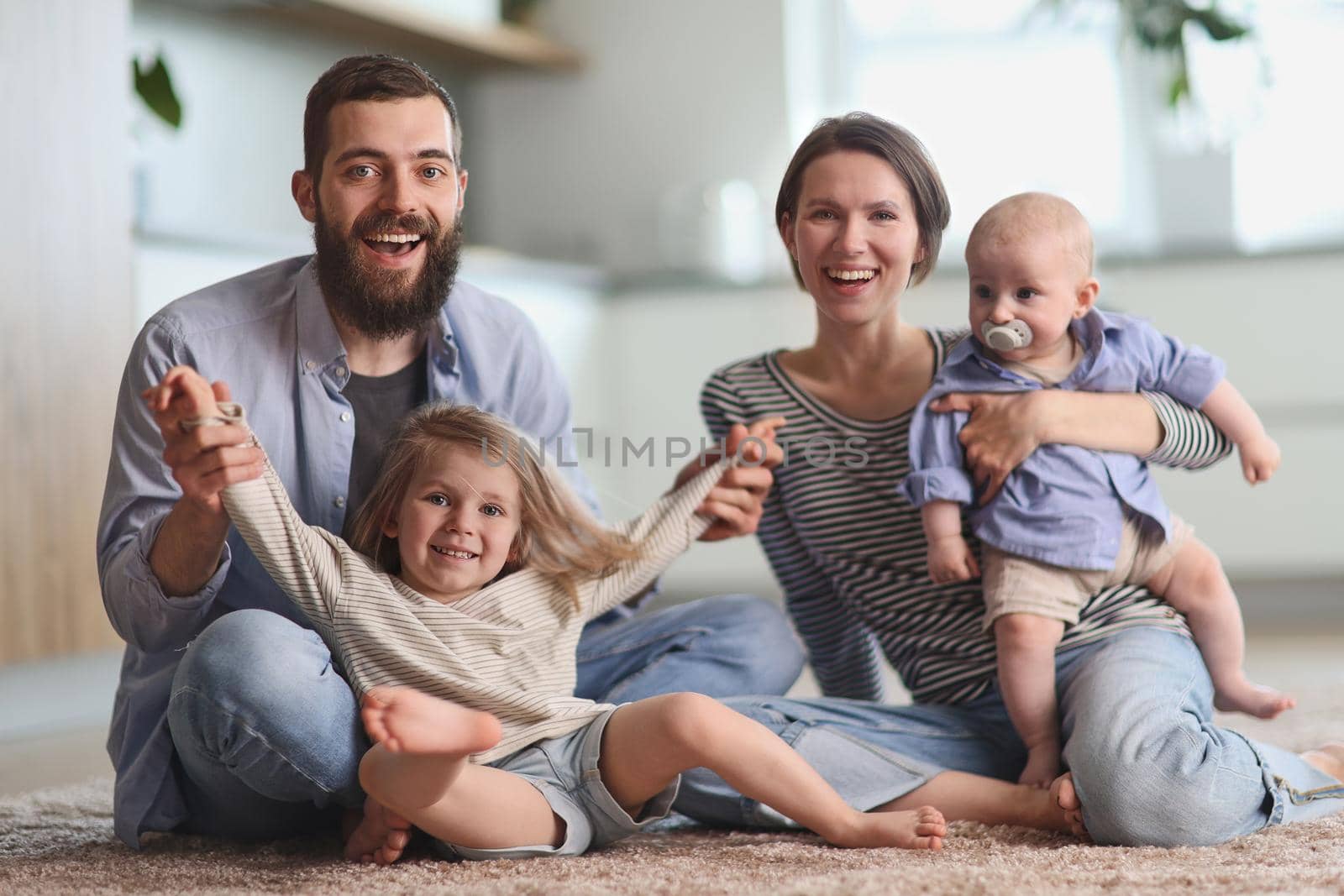 Happy parents playing with children in the kitchen