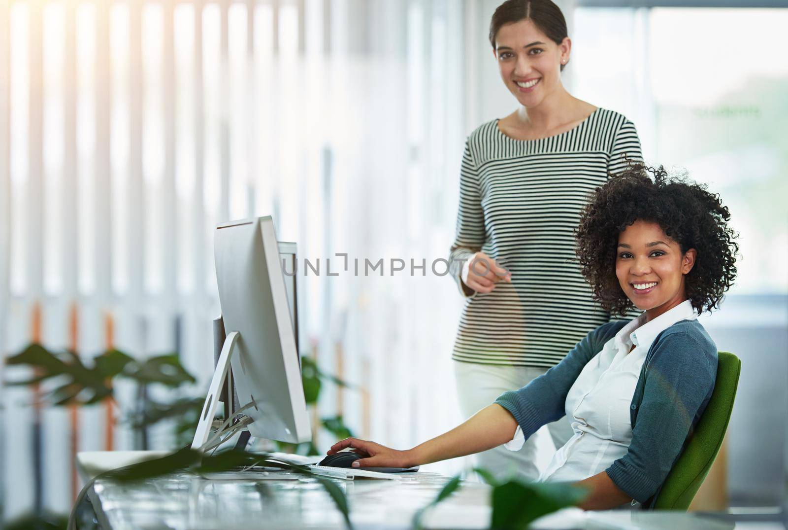 Trainee, intern or new employee with her manager, supervisor or human resources manager in the office. Portrait of happy, smiling and ambitious business women and colleagues at a desk at work.