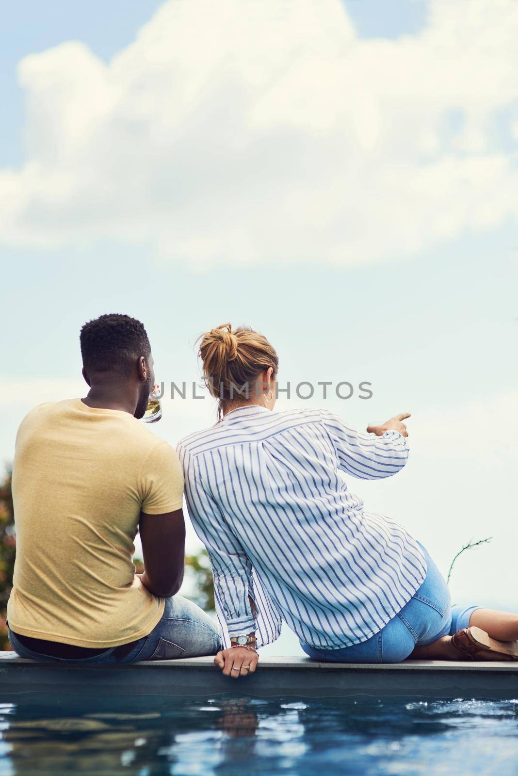Apparently theres a shopping mall over there. Rearview shot of a young couple enjoying drinks together while relaxing outdoors on holiday