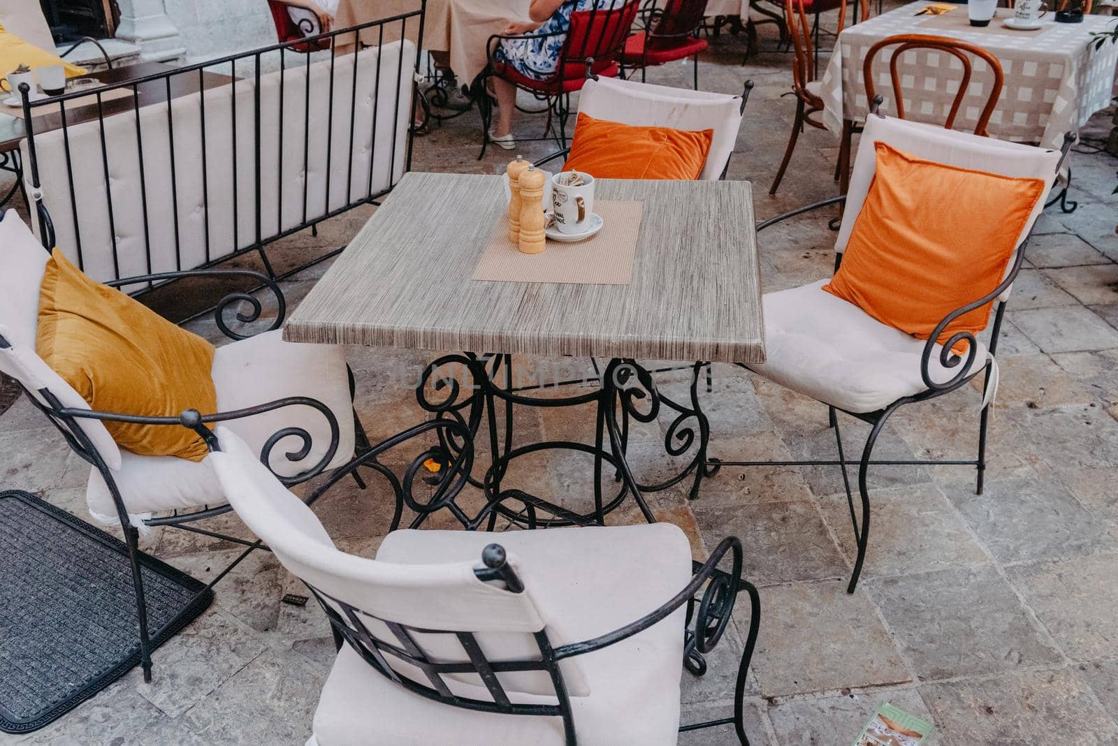 Morning street empty outdoor cafe with traditional wooden chairs waiting for guests or tourists. Cafe terrace in small European city. Summer cafe, empty tables in outdoors cafe in Europe, Coffeeshop, Cafe on the street, outdoors