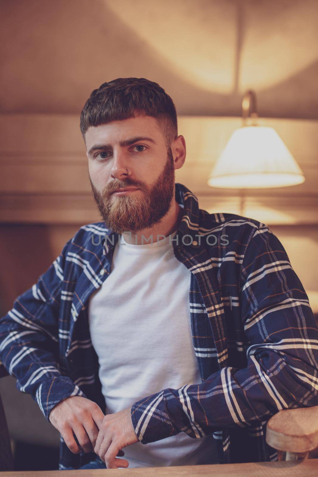 Portrait handsome bearded man wearing plaid shirt at modern cafe by nazarovsergey