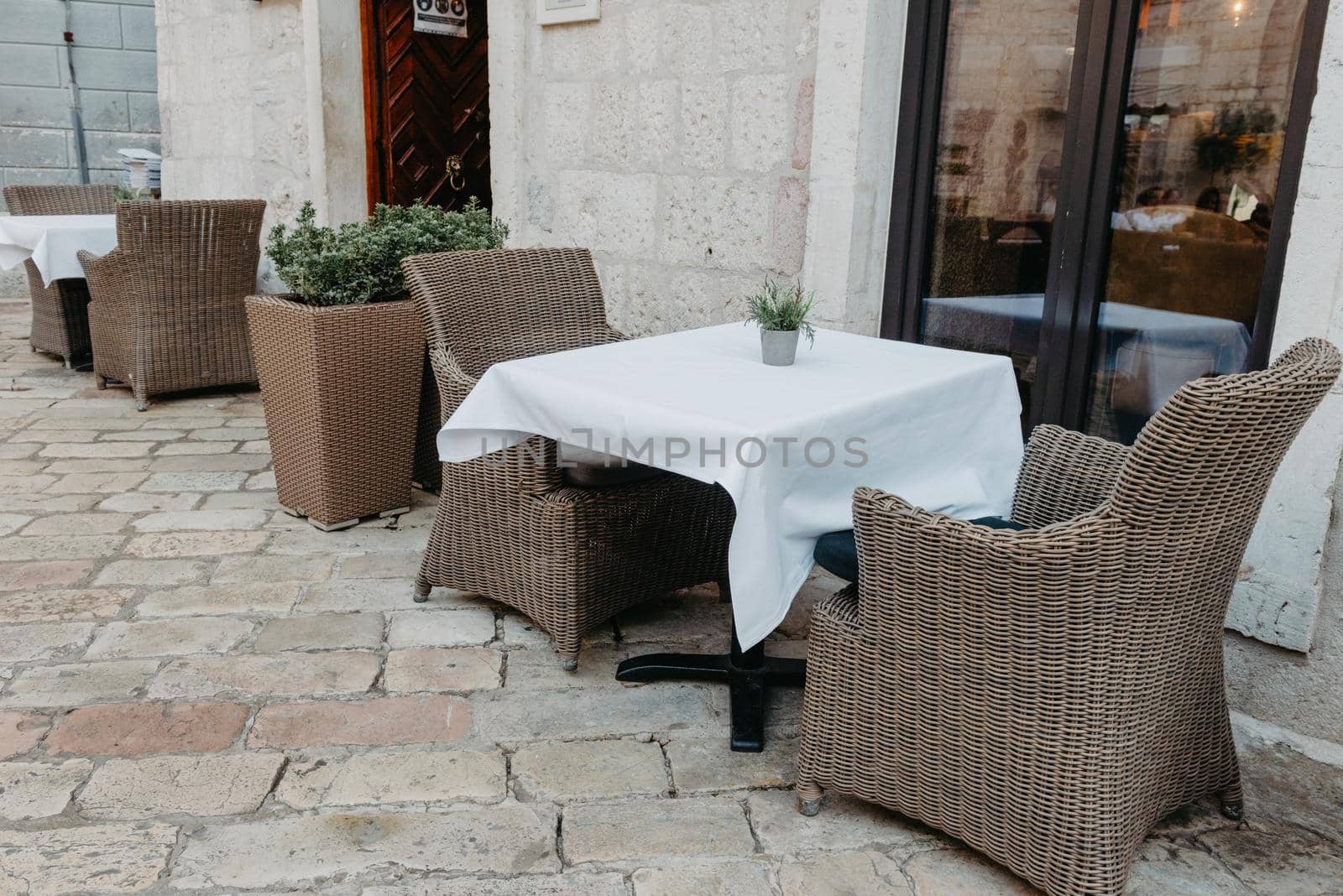 Morning street empty outdoor cafe with traditional wooden chairs waiting for guests or tourists. Cafe terrace in small European city. Summer cafe, empty tables in outdoors cafe in Europe, Coffeeshop, Cafe on the street, outdoors by Andrii_Ko