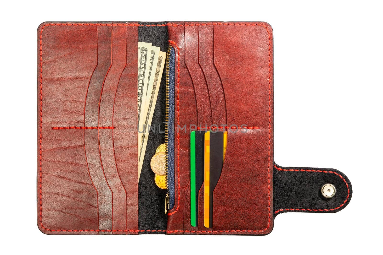 Open red leather clutch with money and credit cards isolated on white background.