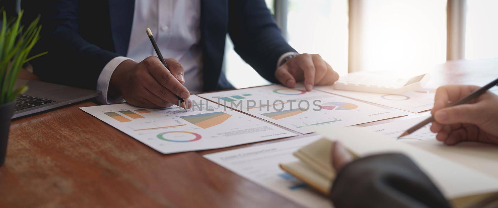 Smart businessman and businesswoman talking discussion in group meeting at office table in a modern office interior. Business collaboration strategic planning and brainstorming of coworkers. by nateemee