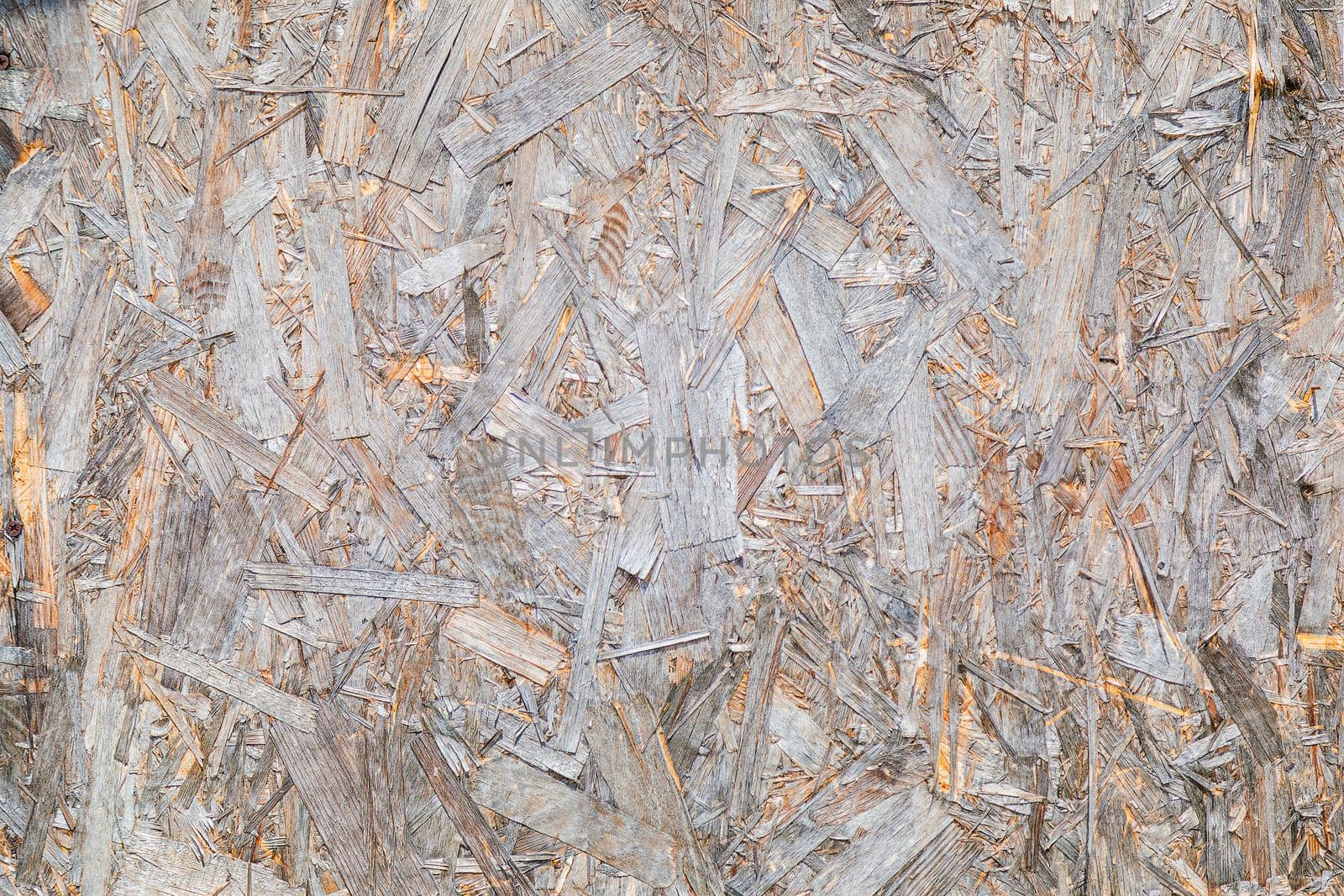 OSB material texture is a board made from recycled pressed wood shavings. Chipboard from large wood waste. Close-up.
