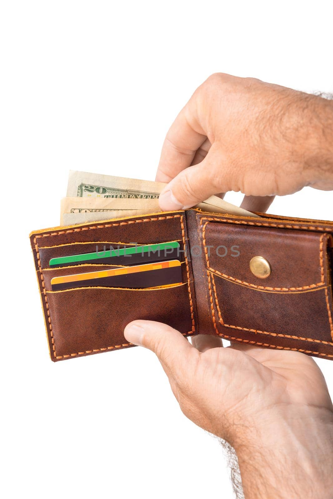 A man is holding an open brown wallet with money and credit cards isolated on a white background close-up