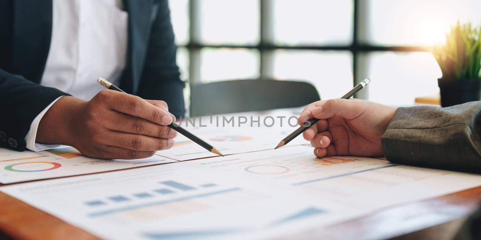 business partnership coworkers discussing a financial planning graph and company during a budget meeting in office room