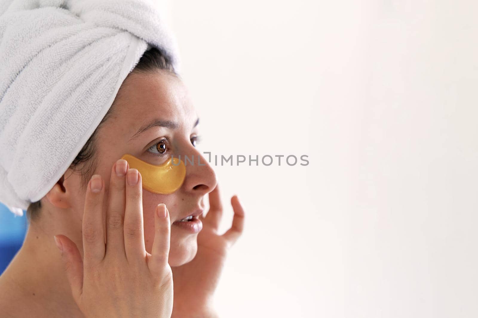 After a shower, the girl is wrapped in a towel and wears cosmetic patches for the skin under the eyes. Cosmetic procedures at home by Try_my_best