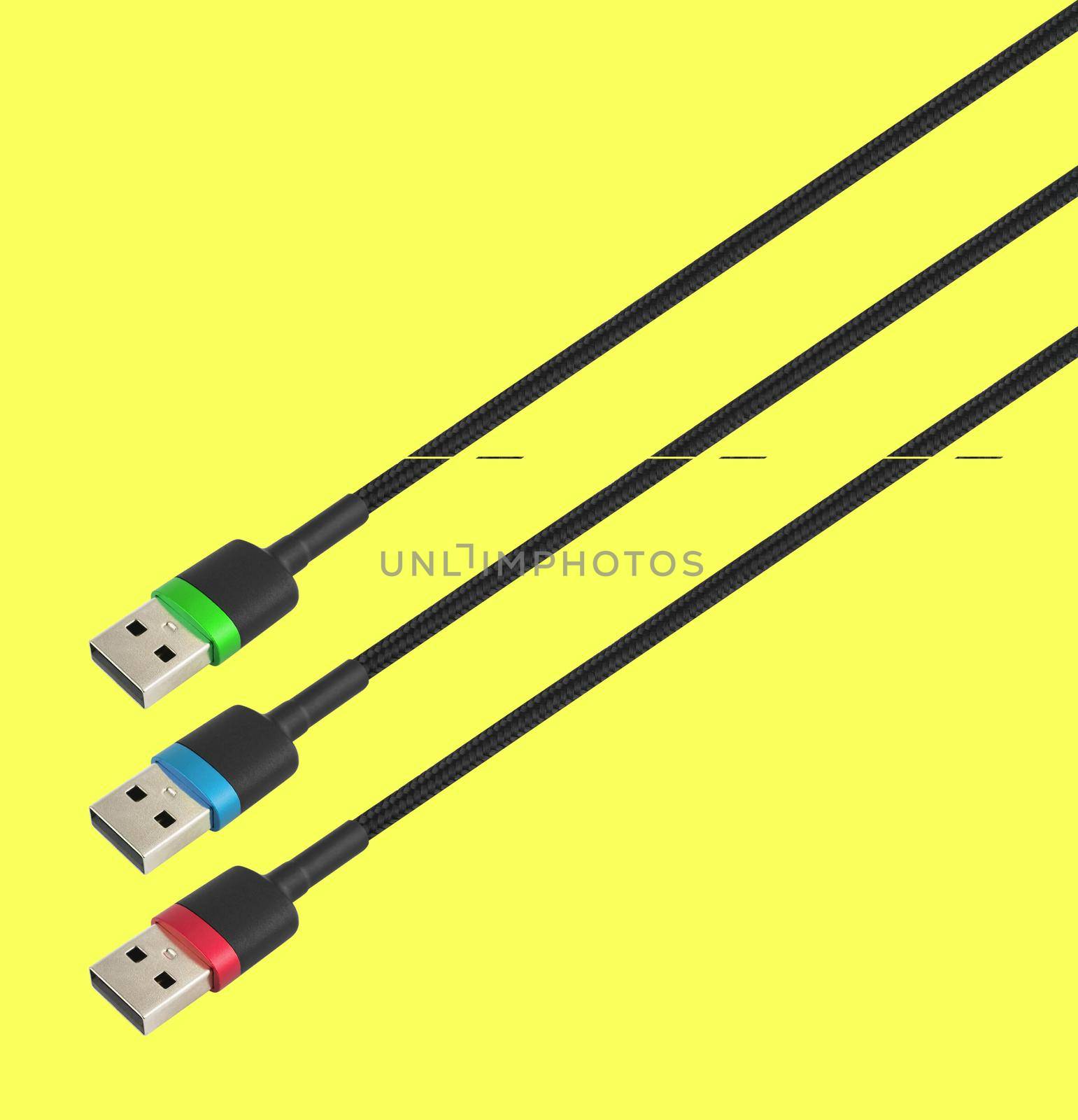 three cables with a USB connector, in RGB colors, isolated on a yellow background