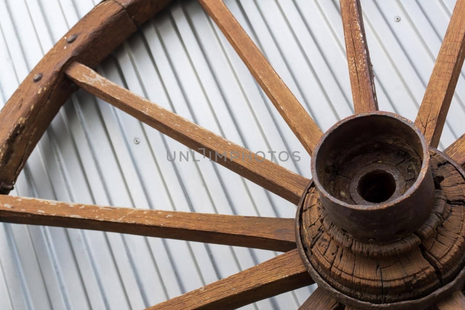 Antique wooden wheel on metallic background close up