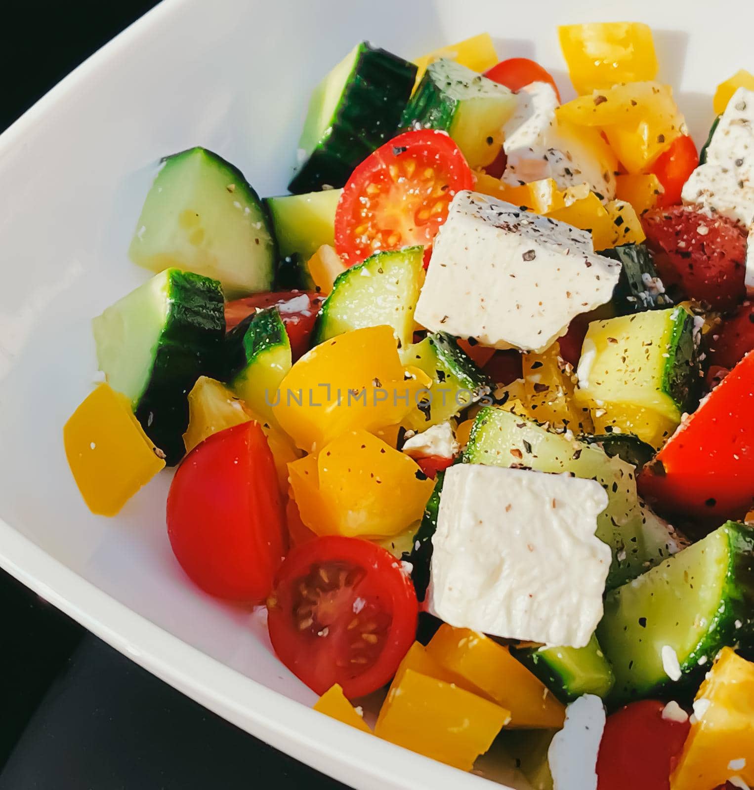 Fresh vegetable greek salad with cherry tomatoes, bell pepper, cucumber, feta cheese, olive oil and seasonal spices, healthy food diet and delicious meal recipe concept