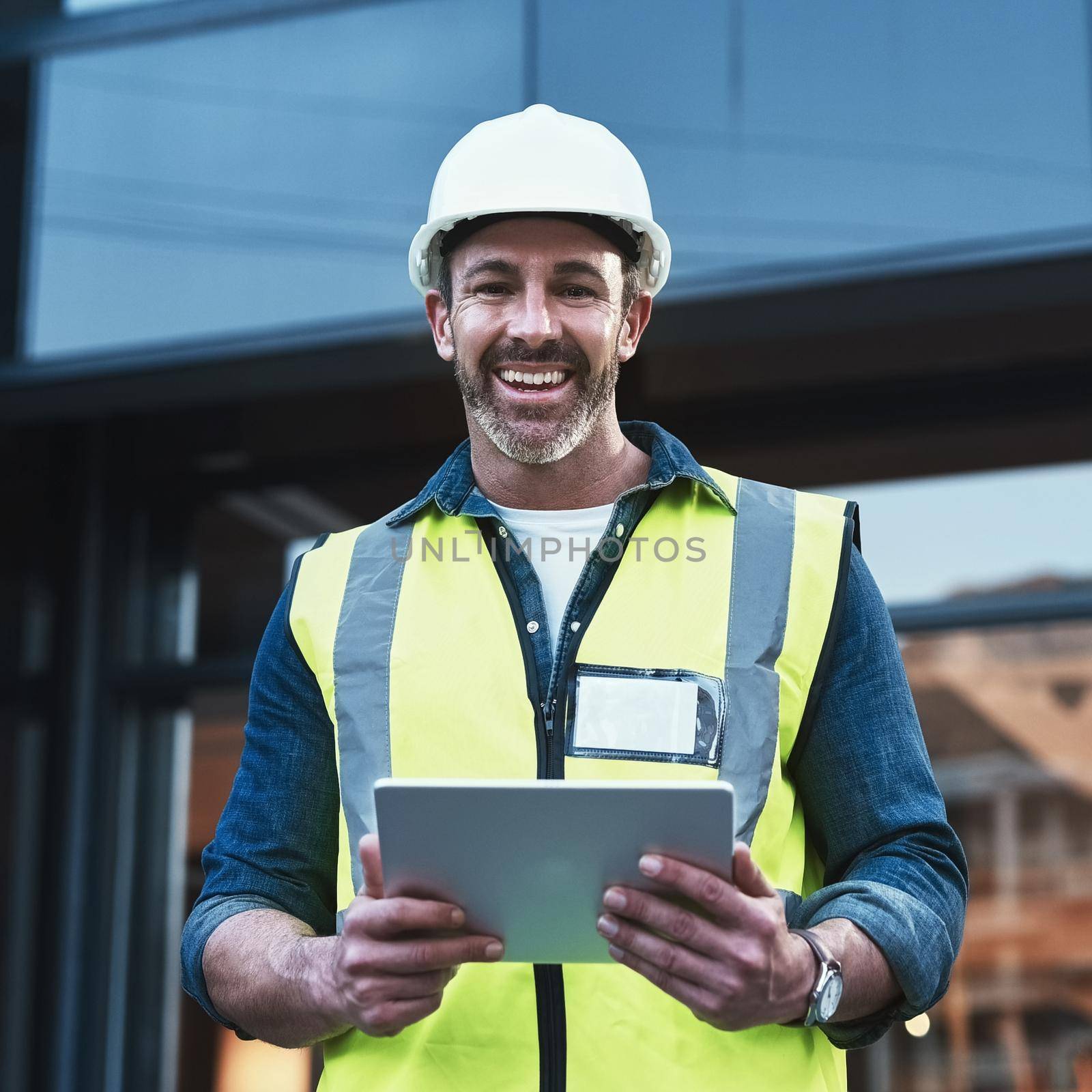 Technology is changing architecture. a engineer using a digital tablet on a construction site. by YuriArcurs